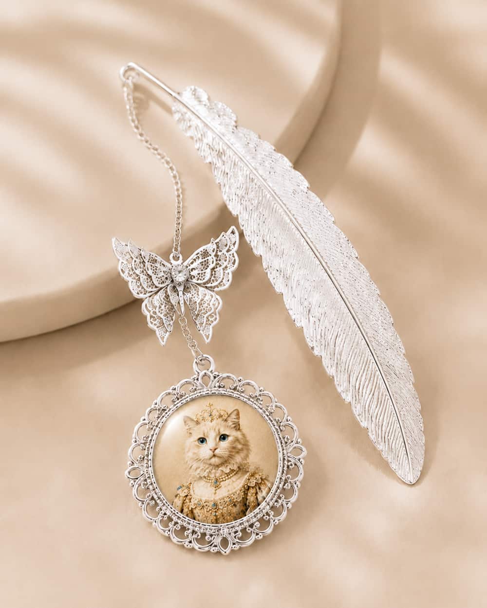 Silver custom pet photo bookmark with royal cat portrait, feather bookmark and butterfly charm.